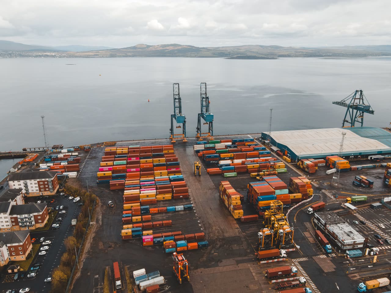 A container terminal seen from above, gantry cranes over stacked containers