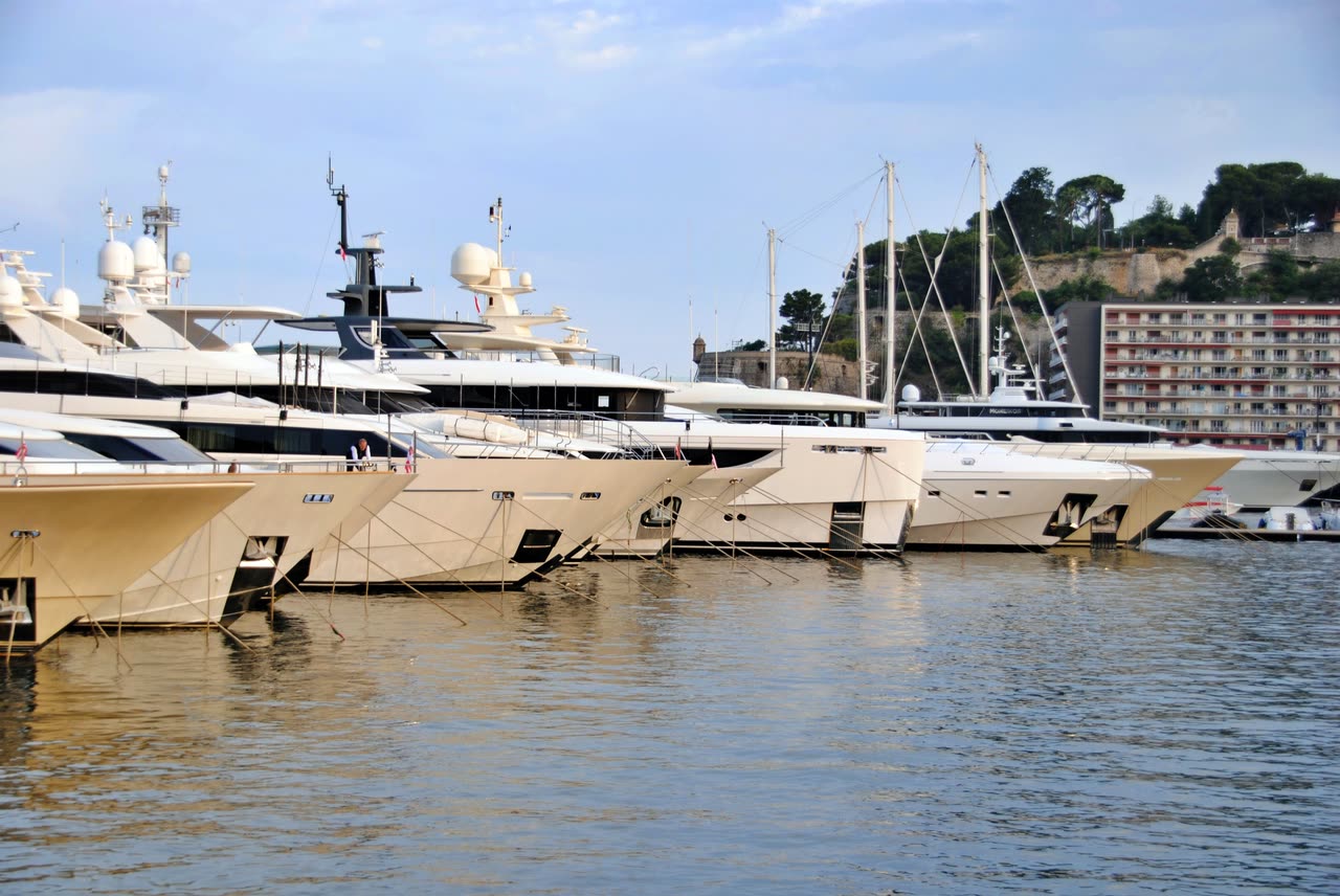 Superyachts moored bow-in along a marina quay
